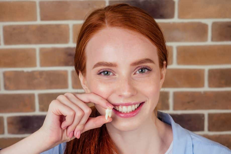 Woman showing her extracted tooth in Milwaukee