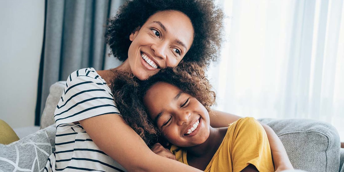 Mother hugging daughter after orthodontic treatment